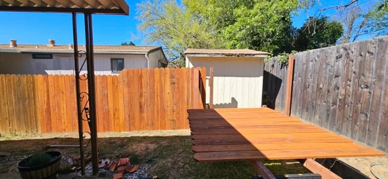 Newly built natural cedar privacy fence with fresh wood deck pad — Maples Landscaping fence build, Mendocino County