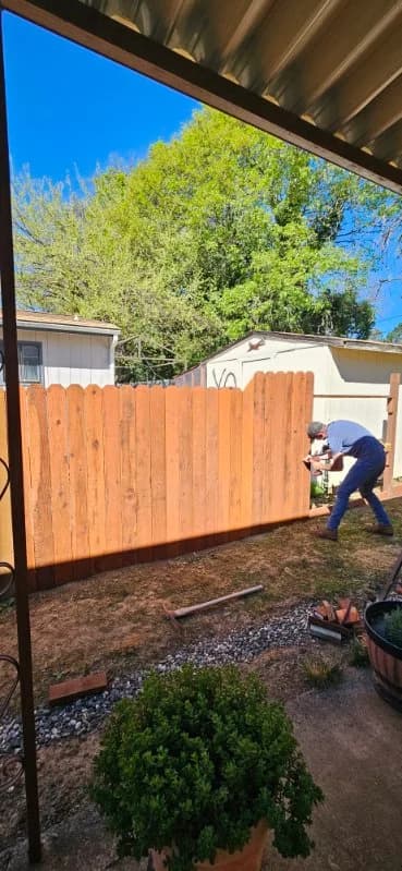 Maples Landscaping crew member installing the last picket on a new natural-cedar fence in Mendocino County